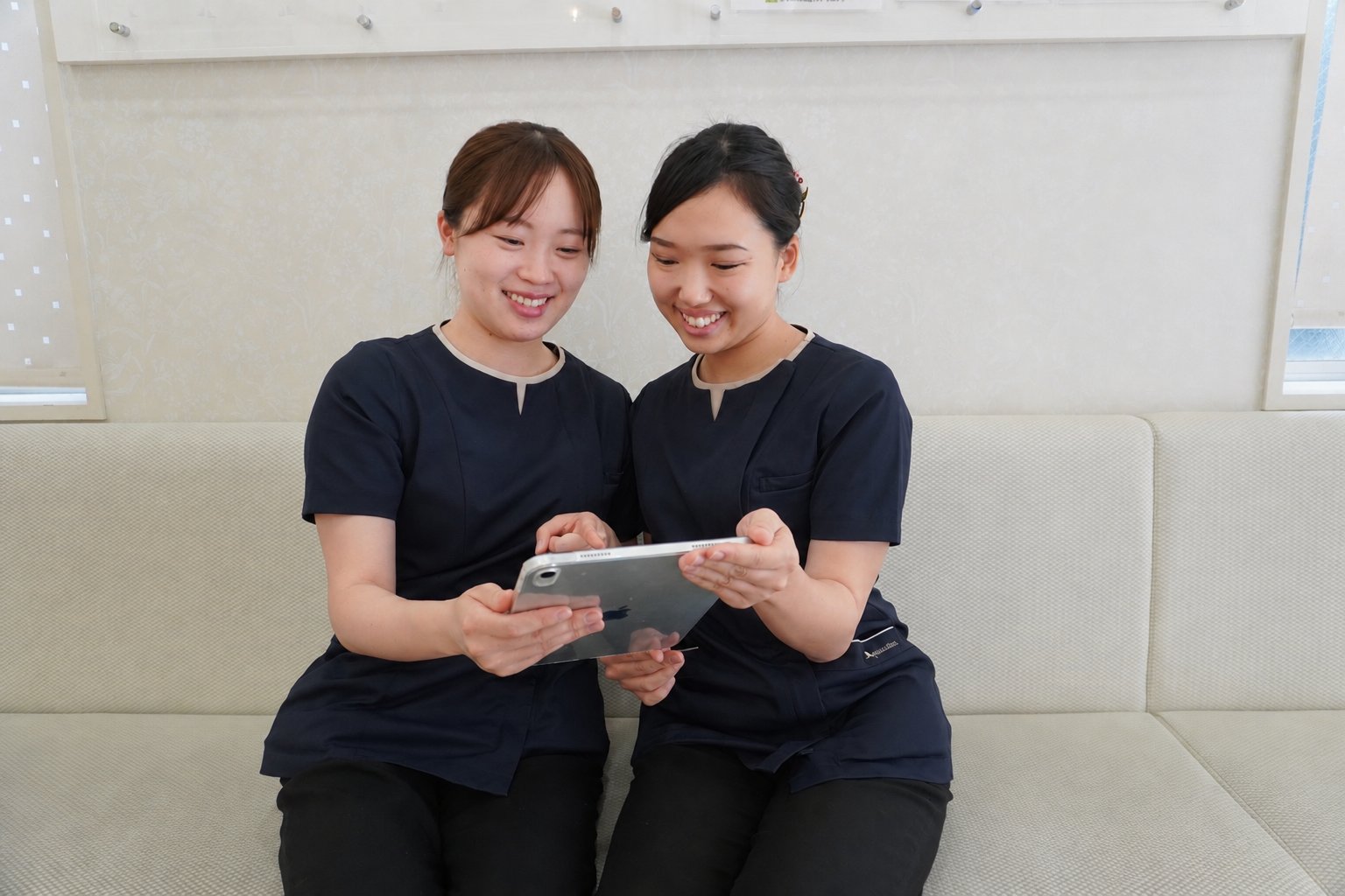 スタッフ2人がタブレットを見ながら目標について話し合う様子