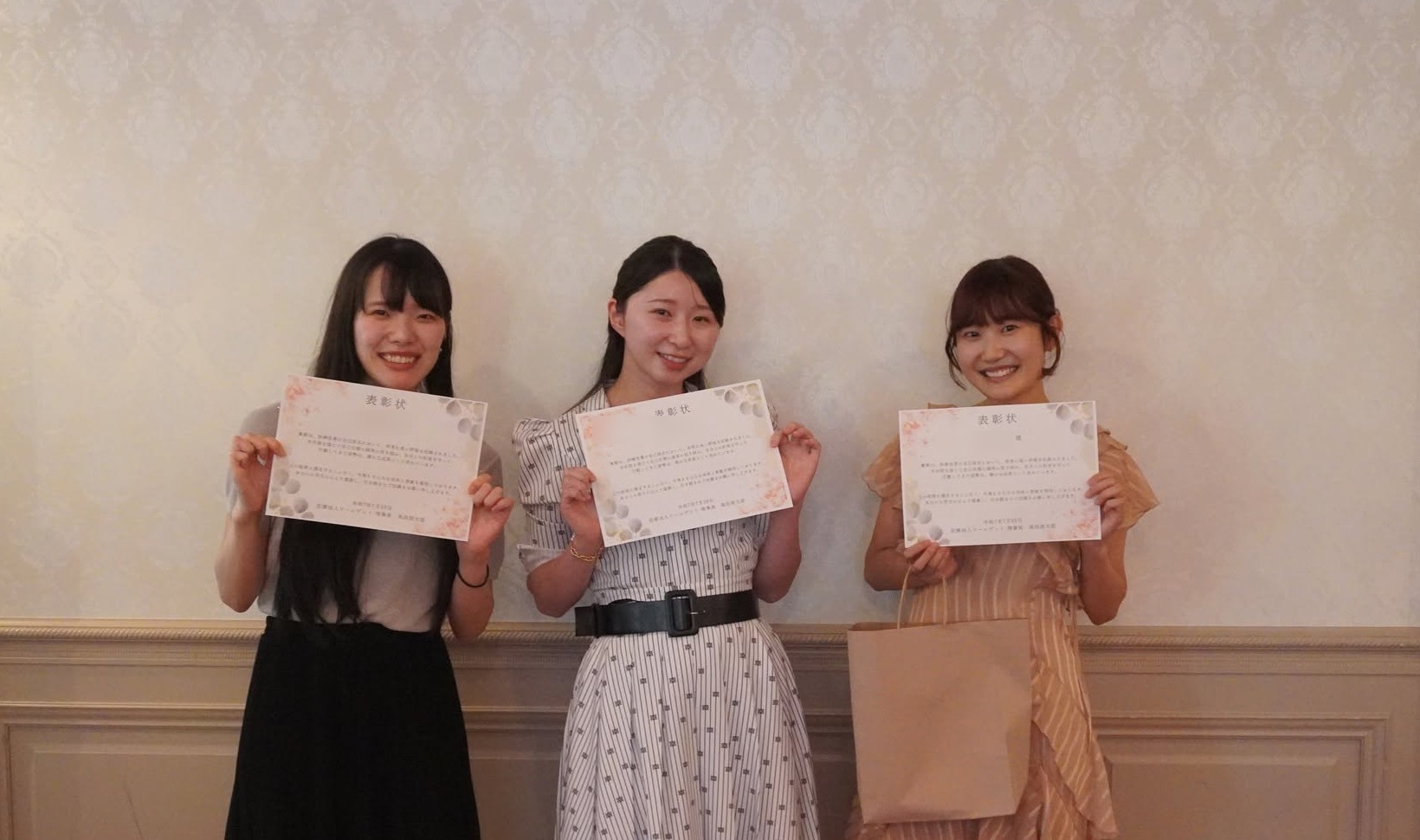 表彰式でスタッフが表彰状を手にする様子