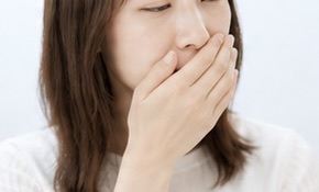 口元を手で覆う女性