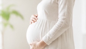 お腹に手を当てる妊婦さん