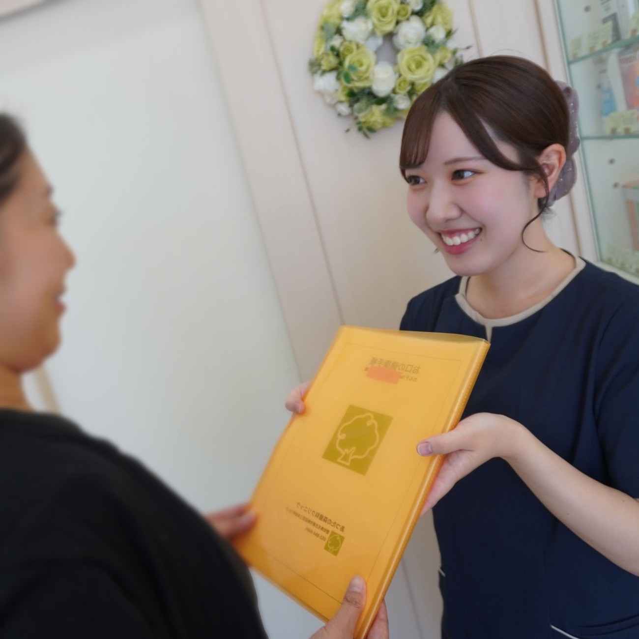 お口の健康手帳を患者さまにお渡しする歯科衛生士